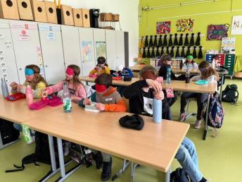 Grundschulkinder frühstücken mit verbundenen Augen